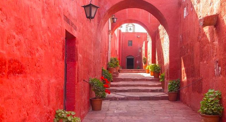 Corredor rojo con arcos y macetas en el Monasterio de Santa Catalina